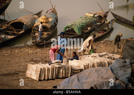 Blocchi di sale sulla riva del fiume con piroghe in background Mopti Mali West Africa Africa Foto Stock