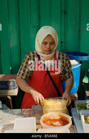 Un venditore ambulante prepara il cibo al suo lato strada stallo alimentare, Kuala Lumpur, Malesia Foto Stock