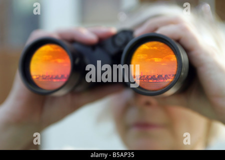 La donna a guardare le corse dei cavalli attraverso il binocolo Foto Stock