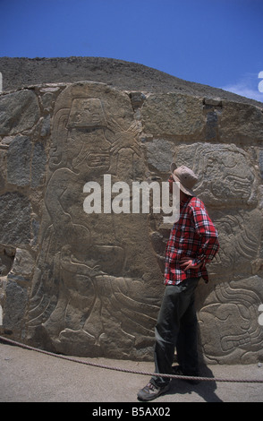 Turistico caucasico faccia a faccia con guerriero in pietra risalente a circa 2000-1500AC nel sito pre-Chavin di Cerro Sechín, Valle Casma, Perù Foto Stock