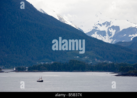 Rimorchiatore commerciale vele le acque del passaggio interno vicino a Sitka Alaska di fronte montagne innevate Foto Stock