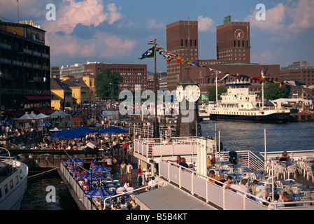 Aria aperta ristoranti attorno al porto, con la torre dell orologio e il Municipio dietro, Oslo, Norvegia, Scandinavia, Europa Foto Stock