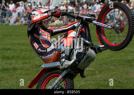 Motociclista acrobatico facendo un'impennata a cavallo sulla sua moto Cowpie Rally Betchworth Surrey Foto Stock