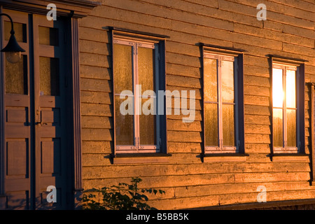 Alla fine del giorno in estate il sole proietta la sua luce su alcune finestre nella città vecchia di Gamlebyen in Fredrikstad Norvegia, a sud di Oslo Foto Stock