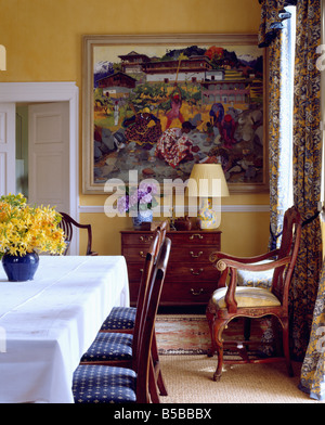 Grande immagine colorata in giallo sala da pranzo con tavolo con Giunchiglie in vaso blu su bianco tovaglia di lino Foto Stock