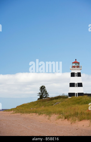 L'erba cresce lungo le dune nella parte anteriore del West Point Lighthouse sulla spiaggia a Prince Edward Island, Canada. Foto Stock