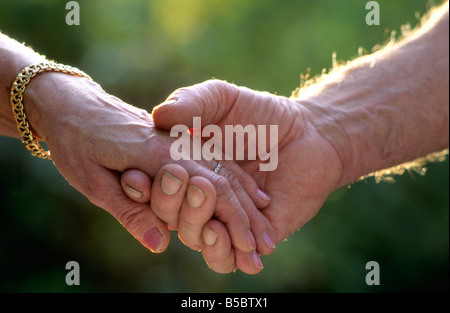 Tenere la mani - due anziani sposati in amore tenendo le mani all'aperto Foto Stock