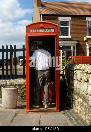 Regno Unito Inghilterra Yorkshire Doncaster uomo utilizzando soggetto ad atti vandalici K6 casella Telefono con porta n. Foto Stock