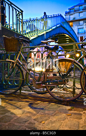 Underview di un ponte metallico con le biciclette in primo piano nel crepuscolo Foto Stock