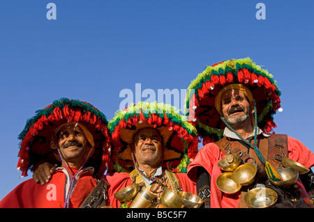 3 uomini in abito tradizionale come portatori di acqua rappresentano per la fotocamera a Djemaa El Fna - la piazza principale del mercato di Marrakesh. Foto Stock