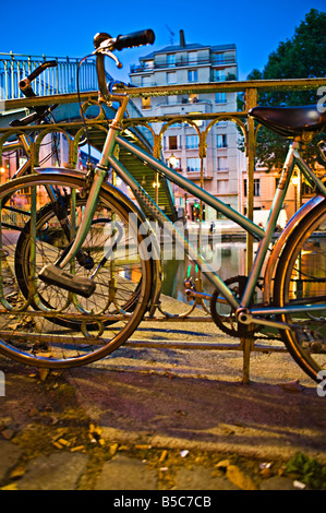 Underview di un ponte metallico con le biciclette in primo piano nel crepuscolo Foto Stock