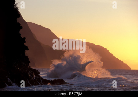 Un'onda si rompe al tramonto sul Na Pali costa, Kauai, Hawaii. Foto Stock