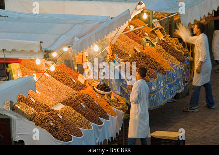 2 Gli uomini di preparare e pulire le loro bancarelle che vendono cibo essiccato a Djemaa El Fna a Marrakech. Foto Stock