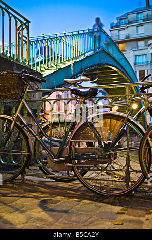 Underview di un ponte metallico con le biciclette in primo piano nel crepuscolo Foto Stock