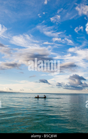 Due pescatori in canoa con regolazione del sole Foto Stock