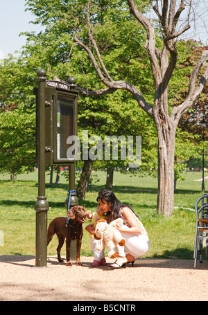 Il coreano asian la madre e il bambino incontra un cane ormeggiato sul Clapham Common Londra Foto Stock