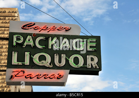 Insegna al neon in Globe, dicendo Confezione di liquori e di pappagallo di rame Foto Stock