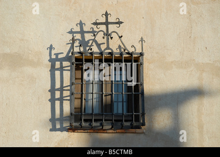 Finestra con in ferro battuto e la raffigurazione di una croce su una casa accanto alla chiesa, Chinchon, Comunidad de Madrid, Spagna Foto Stock