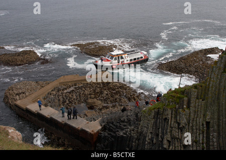 Le visite turistiche, le imbarcazioni da diporto turus mara sbarco presso il molo di pietra sull'isola di staffa in Scozia argyll Foto Stock