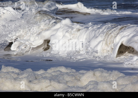 Le onde che si infrangono lungo il litorale, Norfolk Foto Stock