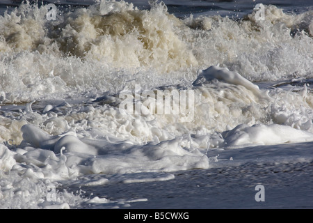 Le onde che si infrangono lungo il litorale, Norfolk Foto Stock