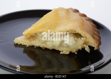 Fetta di irish bramley apple pie torta su una piastra nera Foto Stock