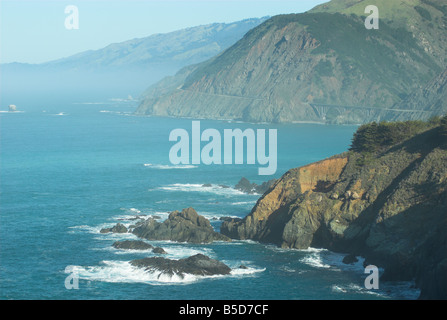 Big Sur costa lungo la California Rt1 in una giornata di sole con un accenno di nebbia in background Foto Stock