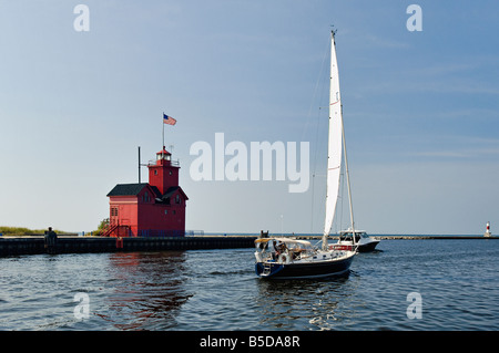 In barca a vela e potenza di crociera in barca passato l'Holland Faro del porto sul Lago Michigan Holland Michigan Foto Stock