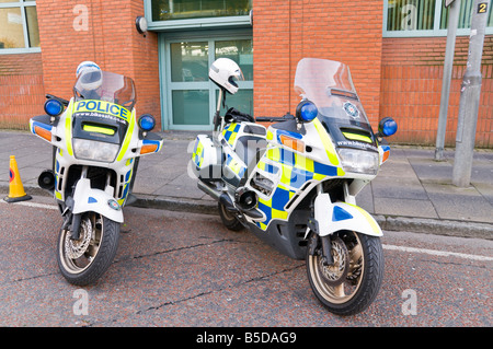 Il servizio di polizia dell'Irlanda del nord (Psni) motocicli parcheggiata in una strada con i caschi sulla parte posteriore Foto Stock