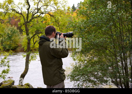 Fotografo utilizzando un D300 con Nikon 70-200mm VR lente fuori dal fiume di Scozia UK Foto Stock