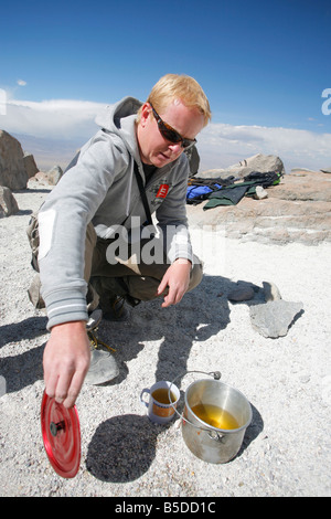 Scalatore versando mate de coca, o di foglia di coca tea al campo base sul monte Vulcano Chachani nei pressi di Arequipa in Perù Foto Stock