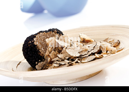 Fette di tartufo su piastra in legno, close-up Foto Stock