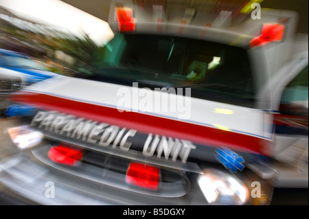 Ambulanza unità di personale paramedico Motion Blur velocizzando il fragore di scena dell'incidente Foto Stock