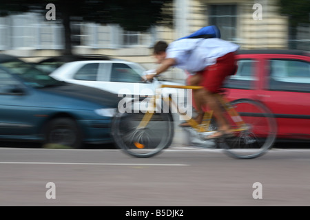 Ciclista accelerando attraverso il traffico Foto Stock