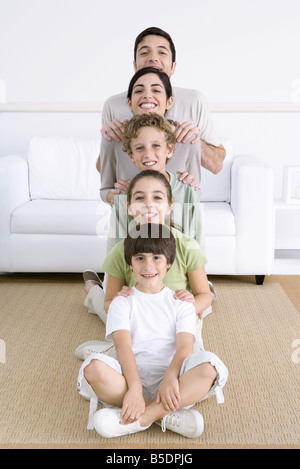 Famiglia schierate più breve al più alto, sorridente in telecamera Foto Stock