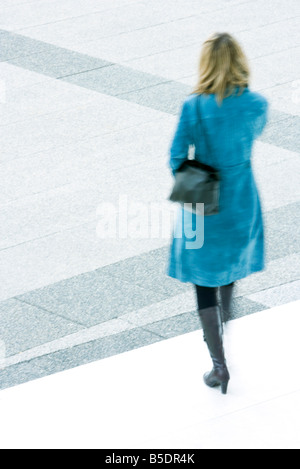 La donna in blu di sovrarivestimento fasi discendente all'aperto Foto Stock