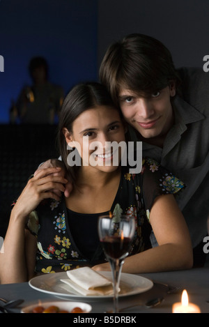 Ritratto di giovane al ristorante, tenendo le mani, sorridente in telecamera Foto Stock