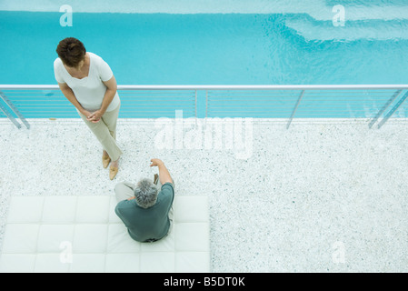 Coppia matura in relax sulla terrazza a bordo piscina, vista aerea Foto Stock