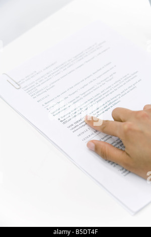 Puntamento a mano in corrispondenza della parola sul documento, vista ritagliata Foto Stock
