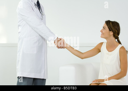 La donna si stringono la mano con il medico, vista ritagliata Foto Stock