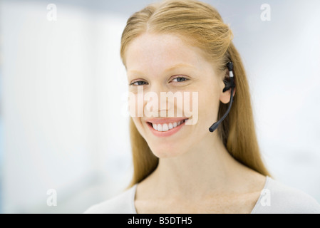 Professional donna che indossa la cuffia, sorridente, ritratto Foto Stock