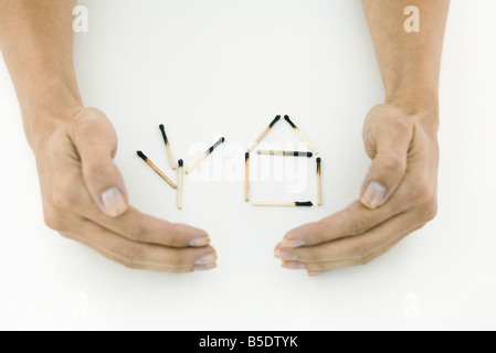 Proteggere le mani bruciate partite organizzate in forma di casa e albero Foto Stock