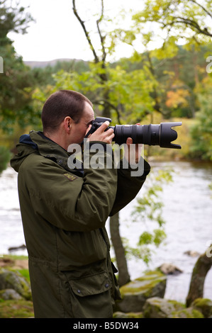 Fotografo utilizzando un D300 con Nikon 70-200mm VR lente fuori dal fiume di Scozia UK Foto Stock