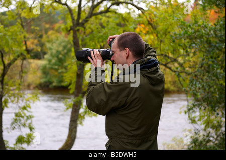 Fotografo utilizzando un D300 con Nikon 70-200mm VR lente fuori dal fiume di Scozia UK Foto Stock