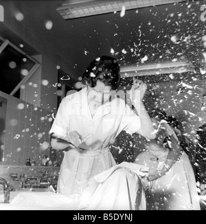 Donne barbieri formazione con gola tagliata rasoi, imparare a radersi utilizzando palloncini. La nostra immagine mostra; uno degli studenti viene irrorato in schiuma da barba dopo il suo balloon burst. Dicembre 1958 Foto Stock