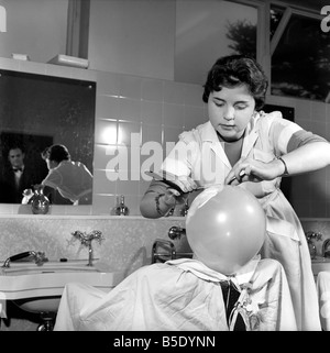 Donne barbieri formazione con gola tagliata rasoi, imparare a radersi utilizzando palloncini. Dicembre 1958 Foto Stock