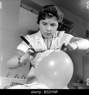 Donne barbieri formazione con gola tagliata rasoi, imparare a radersi utilizzando palloncini. Dicembre 1958 Foto Stock
