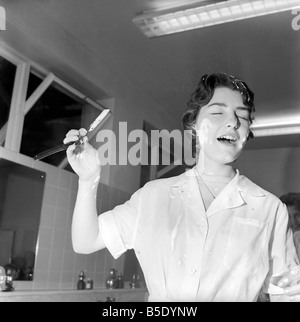 Donne barbieri formazione con gola tagliata rasoi, imparare a radersi utilizzando palloncini. La nostra immagine mostra; uno degli studenti contemplati in schiuma da barba dopo il suo balloon burst. Dicembre 1958 Foto Stock
