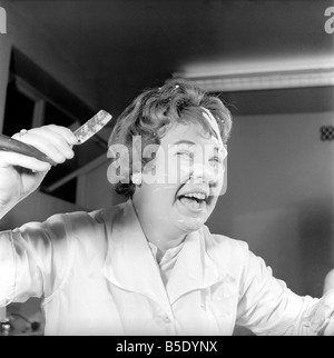 Donne barbieri formazione con gola tagliata rasoi, imparare a radersi utilizzando palloncini. La nostra immagine mostra; uno degli studenti contemplati in schiuma da barba dopo il suo balloon burst. Dicembre 1958 Foto Stock