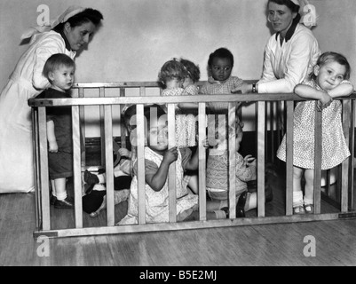 Little baby boy Joey di età compresa tra i 15 mesi e i suoi tre anni suor Margaret, nero bambini che giocano con i loro compagni di gioco bianco nel Elms Naitims Asilo nido in Liverpoo durante la Seconda guerra mondiale. Ottobre 1943 Foto Stock